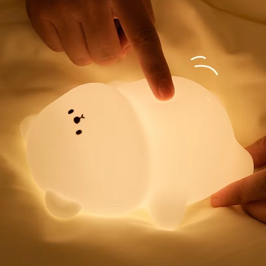 Bebe veilleuse | Douceur Tactile allumée avec un doigt qui presse sur le ventre de l'ours, pour démontrer sa souplesse.