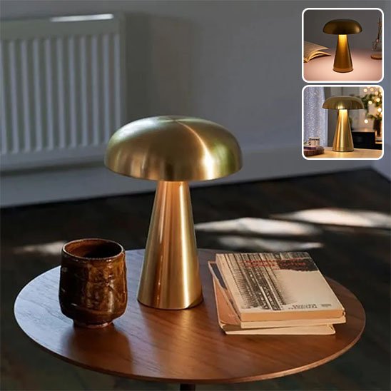 La lampe champignon de couleur or est sur une table ronde à café. Des volumes sont déposés sur un cÎté de la lampe et une verre de l'autre cÎté.