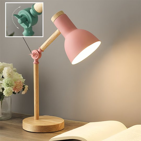 Lampe de chevet LumiTouch de couleur bois, avec un abat-jour rose. L'articulation du bras est rose et il y a une vis de serrage pour immobiliser l'inclinaison de la lampe.