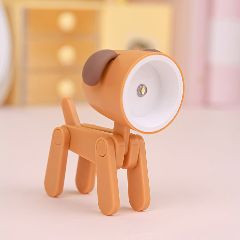 Lampe de bureau articulée en forme de chien de couleur orange avec abat-jour garni d'oreilles de couleur brun orangé. La figure est l'ampoule.
