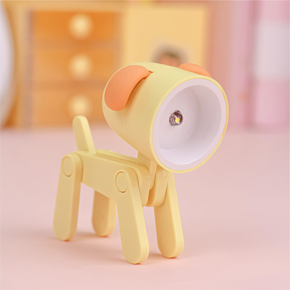 Lampe de bureau articulée en forme de chien de couleur jaune avec abat-jour garni d'oreilles de couleur orange. La figure est l'ampoule.