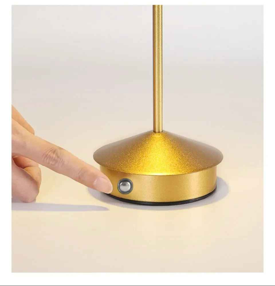 On voit un doigt qui s'apprête à appuyer sur l'interrupteur de la Lampe de table | Scandinave Or situé sur le côté de sa base