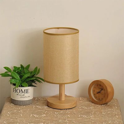 Lampe de table | Scandinave Bois Naturel pose sur un meuble entre une plante et un cadran