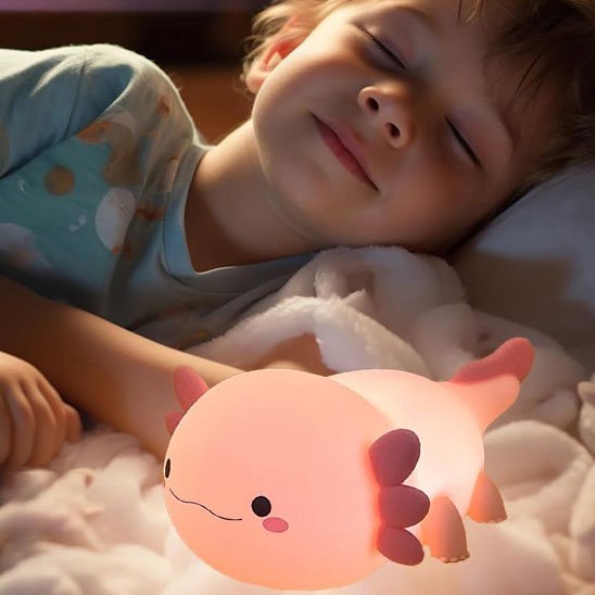 Veilleuse bébé Axolotl Nuit Douce tamisée près d'un petit garçon endormi