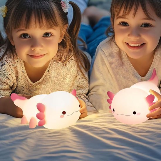 Veilleuse bébé Axolotl Nuit Douce rose entre les mains de 2 fillettes