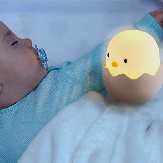 Un bébé dort avec la veilleuse enfant | Poussin Dodo sur son lit