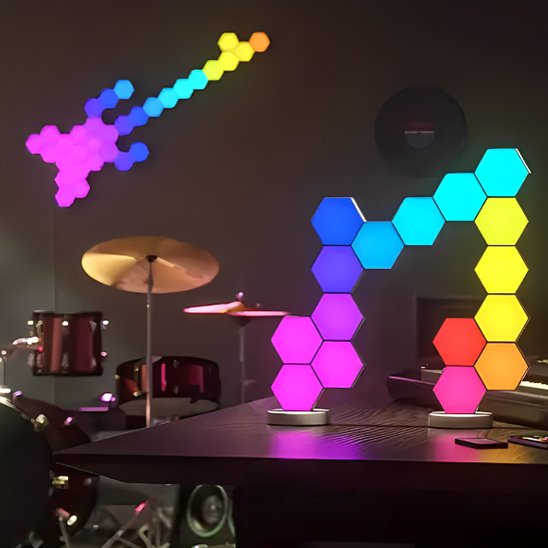 On voit des appliques murales intérieur | DesignHexa formant une forme de guitare électrique, installées au mur d'une piÚce dédiée à la musique, sur un bureau, plus en avant sur la photo, on y voit un montage de 16 appliques formant une note de musique.