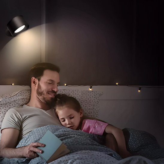 On voit un papa qui lisait une histoire à sa fillette qui s'est endormie éclairés par l'applique murale chambre | Design Luminescence