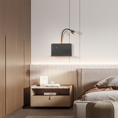On voit l'applique murale pour chambre | DesignFunction de couleur noire installée au mur au-dessus d'une table de chevet. Sa lumiÚre est tournée vers le lit.