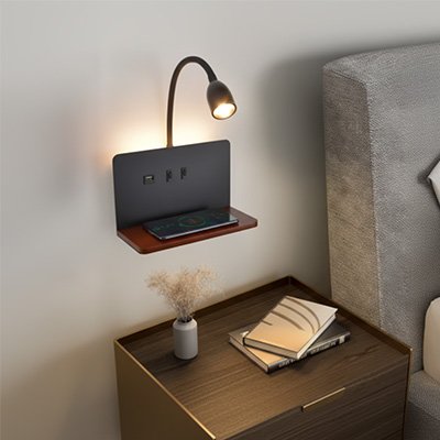 On voit l'applique murale pour chambre | DesignFunction de couleur noire avec un cellulaire posé sur sa tablette de couleur noyer. L'applique est installée au mur au-dessus d'une table de chevet.