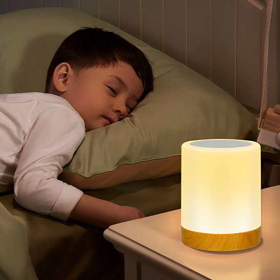 Lampe de chevet | Lumina est allumée sur la table de chevet d'un petit garçon paisiblement endormi