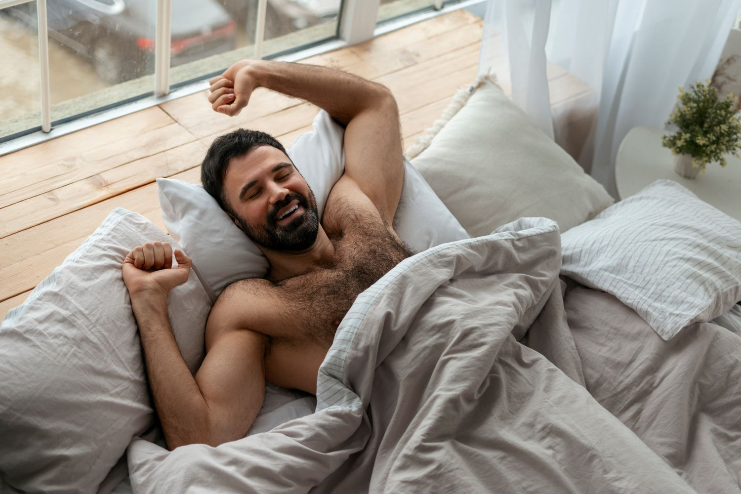 Un homme qui s'étire dans son lit