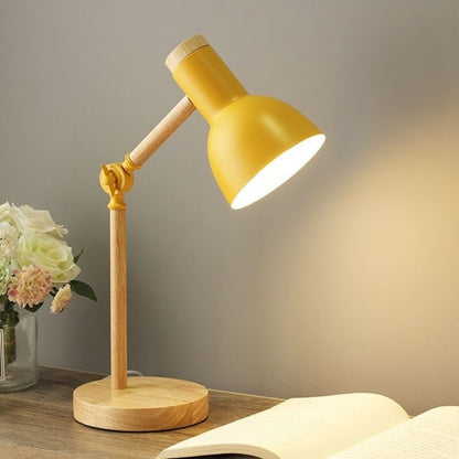 Lampe de chevet de couleur bois, avec un abat-jour jaune. L'articulation du bras est jaune et il y a une vis de serrage jaune, pour immobiliser l'inclinaison de la lampe. 