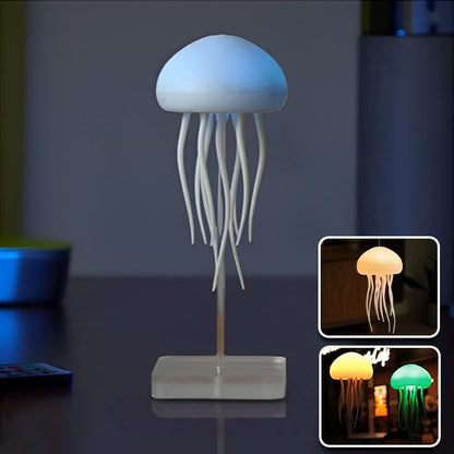 Lampe de table en forme de méduse  qui est blanche une fois éteinte. Sa base et son bras sont translucides. Deux encarts montrent la lampe allumée de différentes couleurs dans une chambre et à l'extérieur devant un Pub.