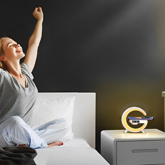 Lampe de chevet design | Réveil LED Couleur blanche. Simulation des couleur de l'aube au réveil. Une femme s'étire, toute souriante dans son lit et la lampe est au couleurs du soleil levant.