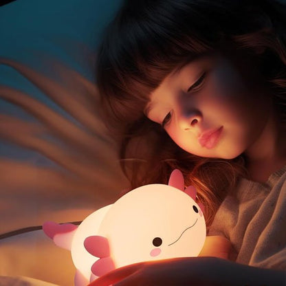 Veilleuse bébé Axolotl Nuit Douce rose entre les mains d'une fillette