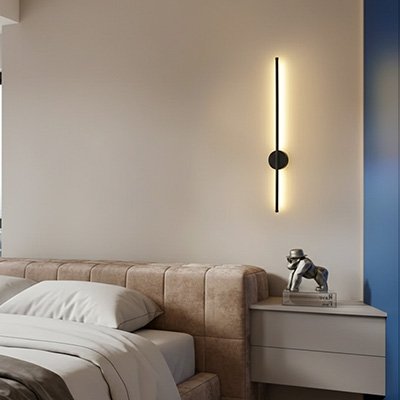 On voit une applique murale pour chambre | Cozy Elegance noire installée au-dessus d'une table de chevet sur laquelle est posée un statuette