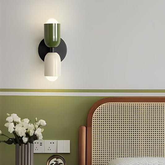 On voit une applique murale chambre | Design Ajustable l'abat-jour du haut est vert, celui du bas est blanc et le châssis noir. L'applique est installé   au-dessus d'une table de chevet  sur le mur, dont le haut est de couleur blanc et le bas est vert